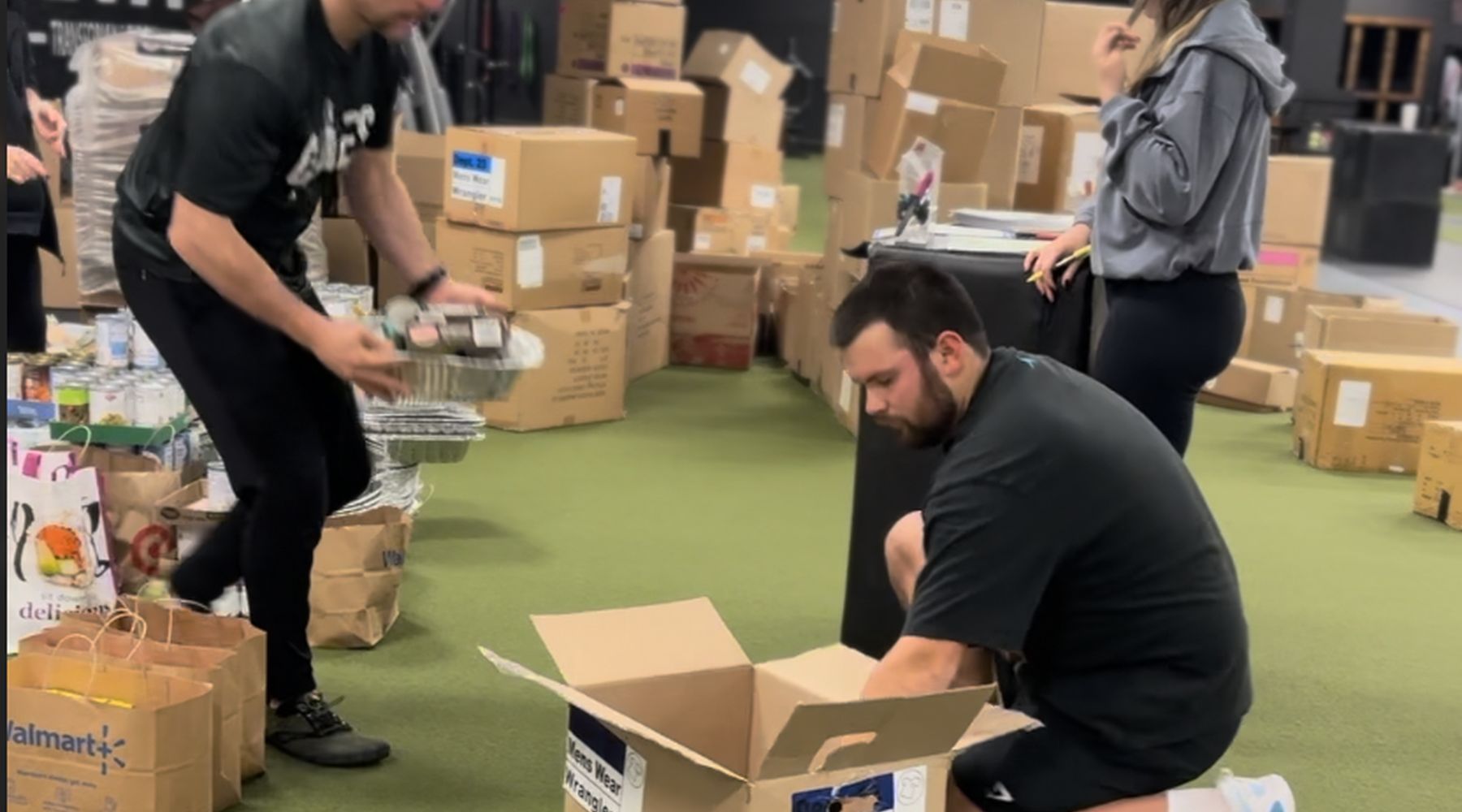 Volunteers packing boxes on the gym floor at THE GYM in Queensbury