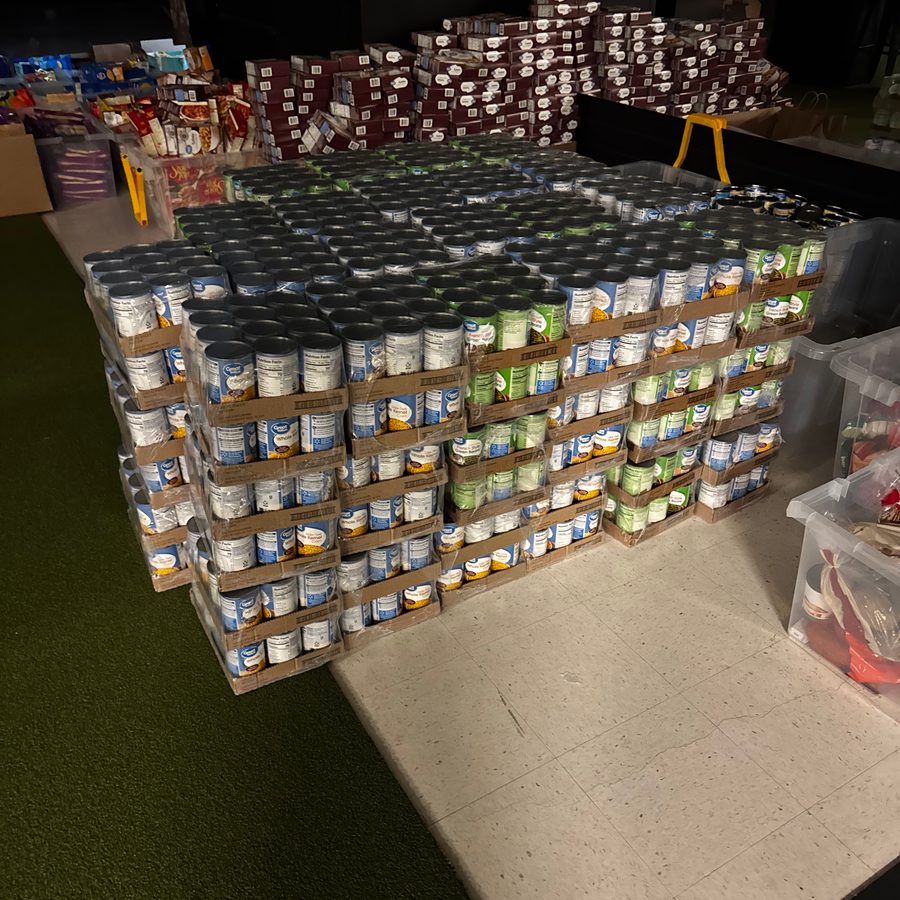 Pallets of canned goods staged on the gym floor